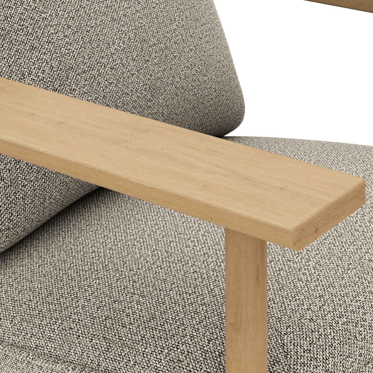 Närbild av ett ljus ekarmstöd på en grå, texturerad soffa med kudde.