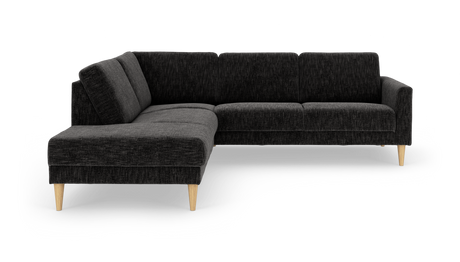 Mörkgrå L‑formad hörnsoffa med schäslong och koniska ben i ljust trä, frilagd på vit bakgrund.