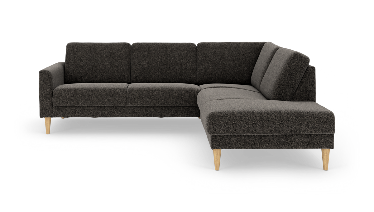 Mörkgrå L‑soffa med schäslong till höger och ljusa träben, modern design frilagd på vit bakgrund.