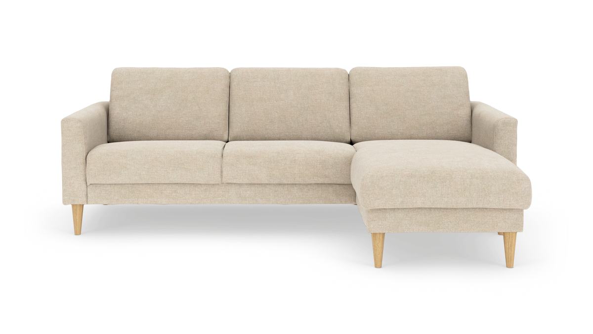 Beige hörnsoffa med schäslong till höger och koniska träben, frilagd på vit bakgrund.