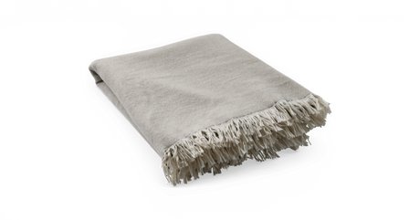 Beige fransad pläd, hopvikt och frilagd mot neutral bakgrund.