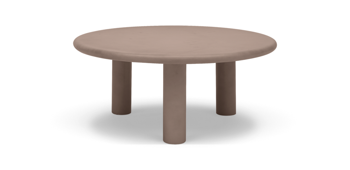 Runt lågt soffbord i beige med tre cylinderben, frilagd bakgrund.