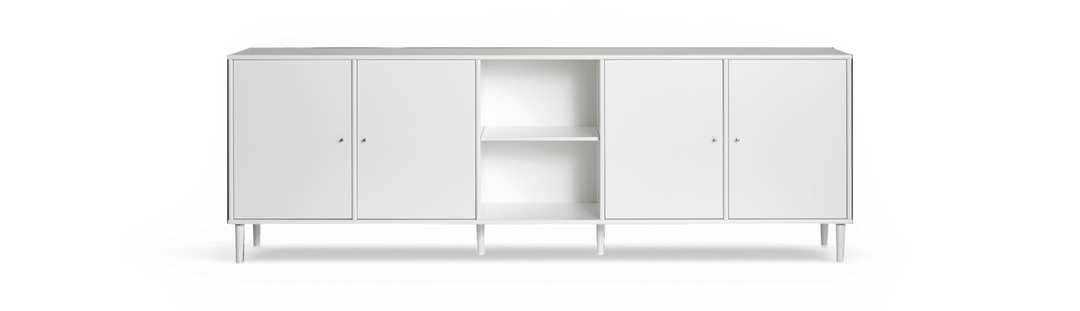 Vit sideboard med fyra dörrar och öppna hyllor i mitten, slanka ben, frilagd mot svart bakgrund.