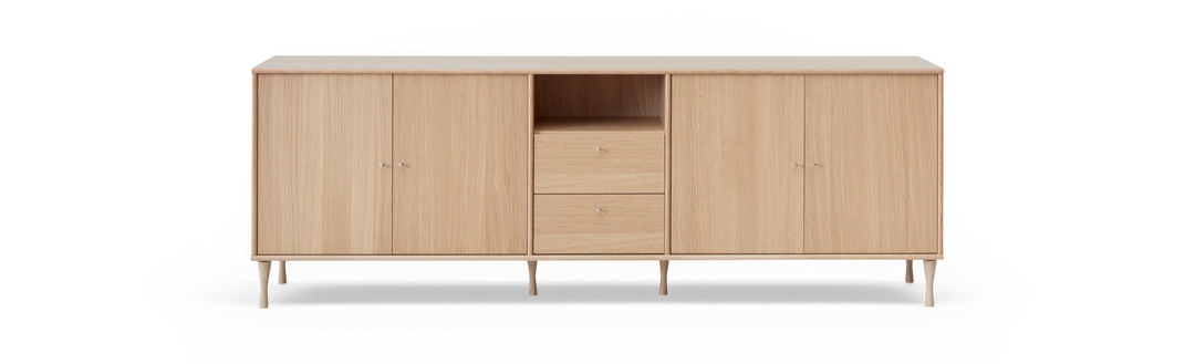 Sideboard i ljus ek med fyra dörrar, två lådor och öppen hylla, frilagd produktbild framifrån.