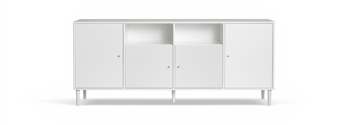 Vit minimalistisk sideboard med fyra dörrar, två öppna fack och smala ben, fotograferad rakt framifrån mot svart bakgrund.