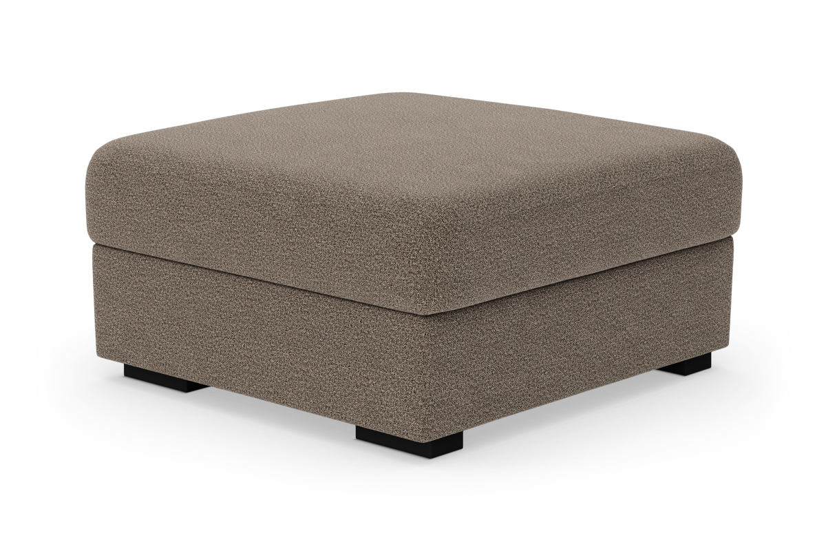 Fyrkantig puff/ottoman i beige tyg med låga svarta ben, frilagd på vit bakgrund.