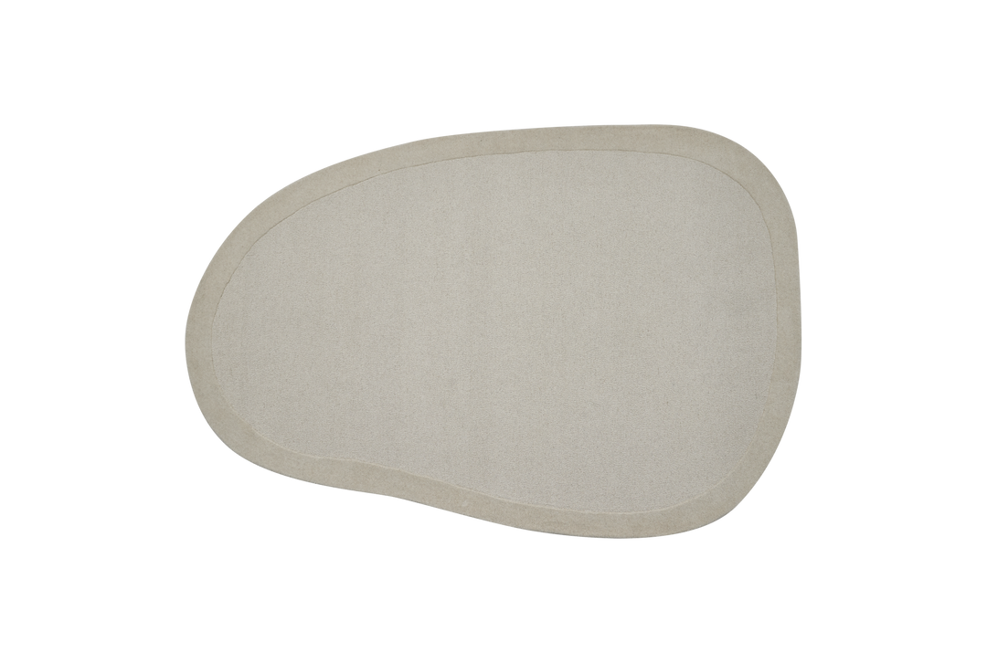 Oregelbunden, beige matta med mjuk kant på vit bakgrund.