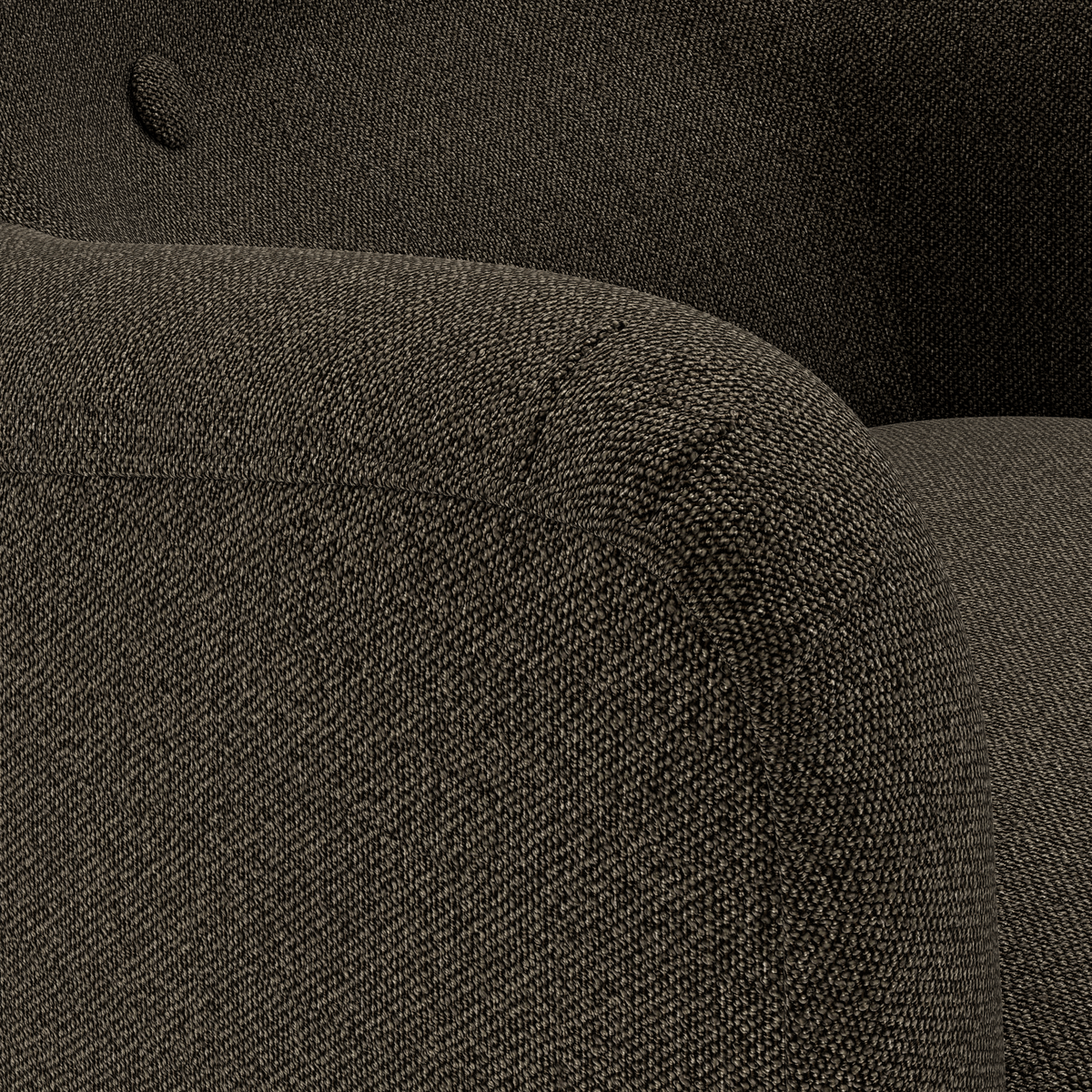 Närbild av mörkgrå, rundad soffarm i texturerat tyg med diskret knapdetalj i ryggen.