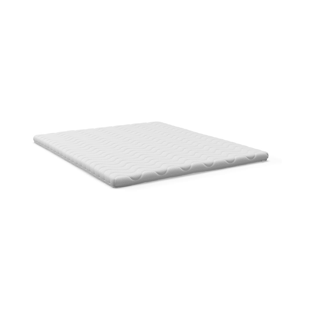 Vit bäddmadrass med vågig quiltning på vit bakgrund.