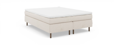 Kontinentalsäng i beige med vit bäddmadrass och slanka träben; logotypen ”nocturne by Tempur” synlig på underdelen.