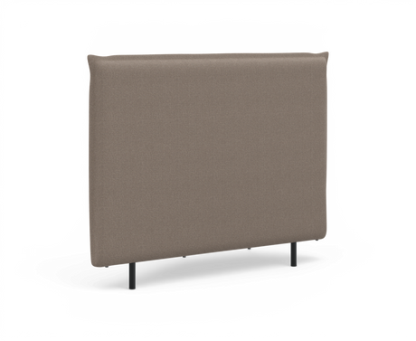 Klädd sänggavel i beige tyg med smala svarta ben, frilagd på vit bakgrund.