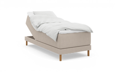 Beige ställbar säng med upphöjd huvuddel, vit bäddning och träben, frilagd på vit bakgrund.