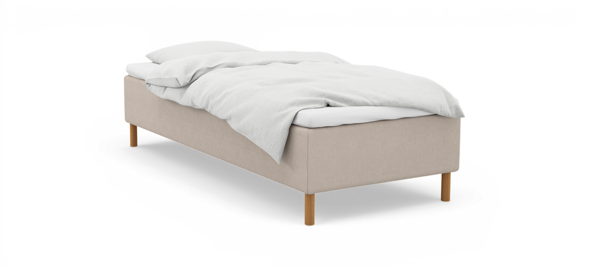 Enkel säng med beige stoppad sängram, vita sängkläder och träben, frilagd på vit bakgrund.
