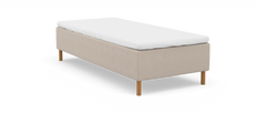 Beige sängbotten med vit bäddmadrass och runda träben, frilagd på vit bakgrund.