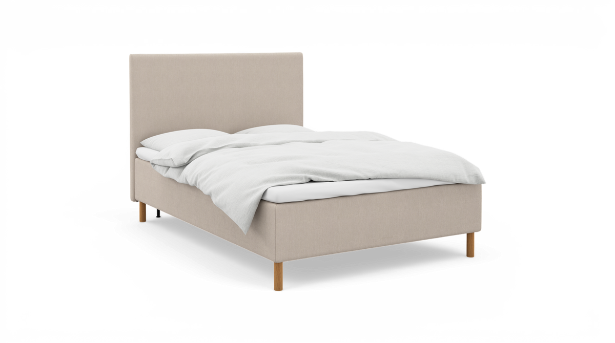 Beige stoppad säng med vit bäddning och träben, frilagd.