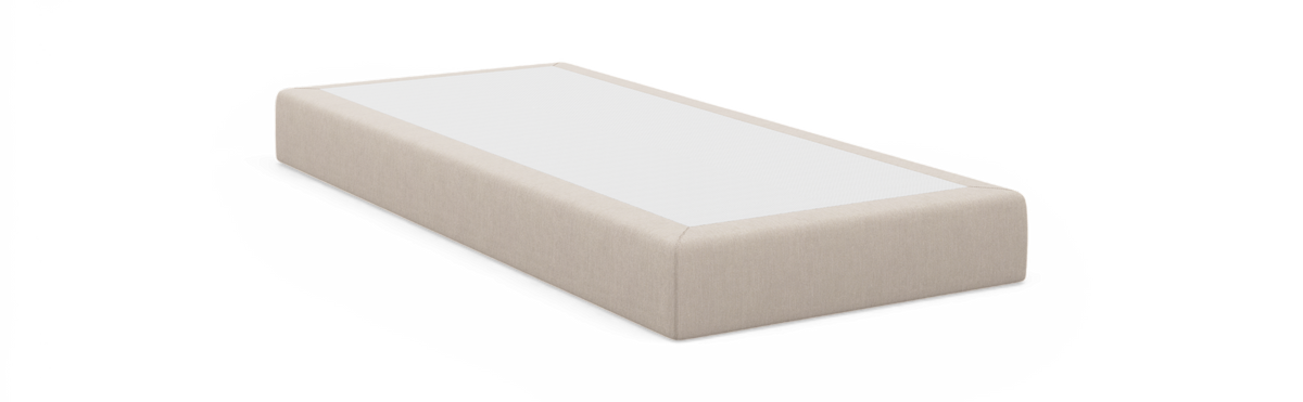 Beige sängbas/boxmadras med vit topp fotograferad i studio på vit bakgrund.