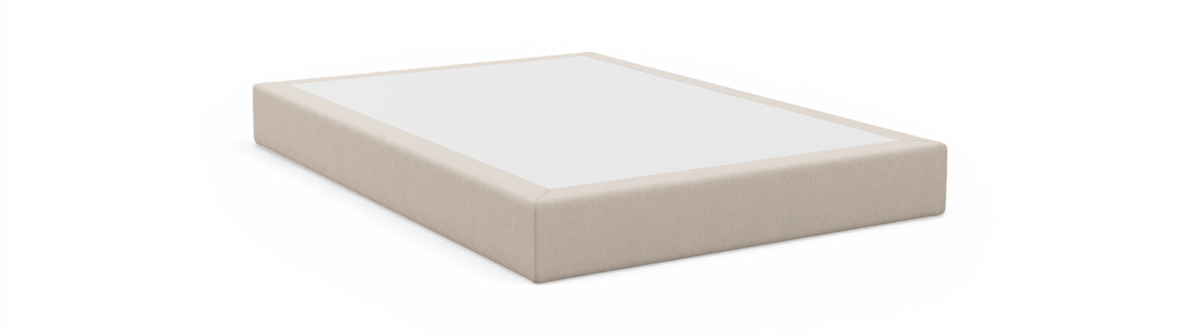 Beige sängbotten/boxspring med vit ovansida, fotograferad i studio i sned vinkel.