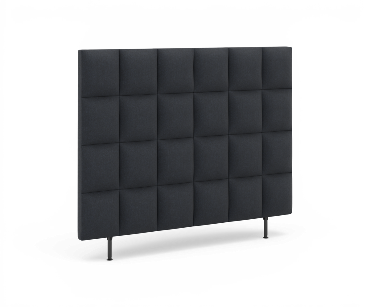 Mörkgrå tygsänggavel med rutad, vadderad design och smala ben.