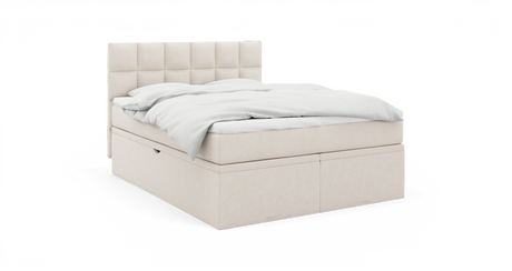 Beige stoppad säng med rutquiltad gavl och vit bäddning, produktfoto i studiomiljö från sned framvinkel.