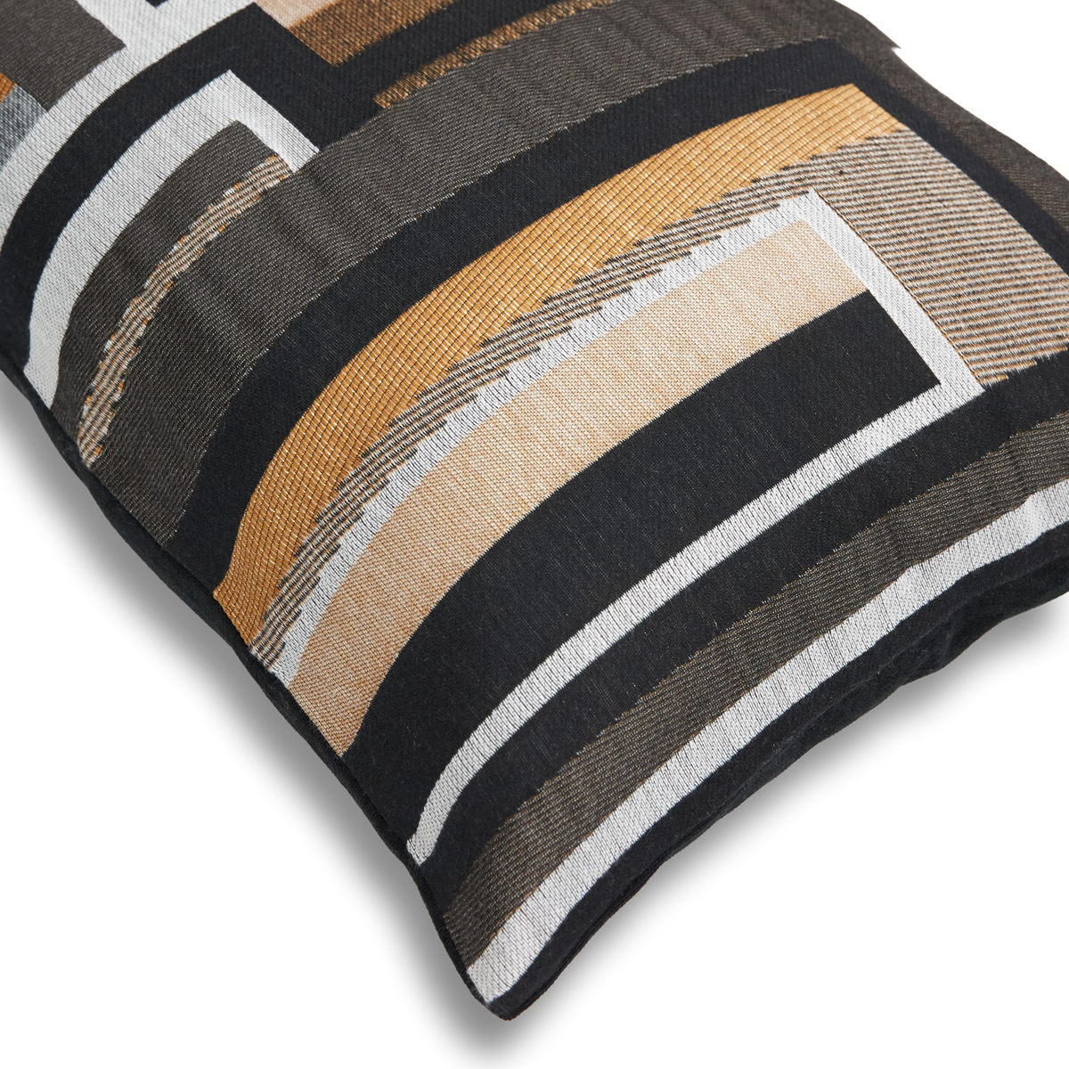 Närbild av dekorationskudde med svart, vit, grå, beige och senapsgul geometrisk randdesign på vit bakgrund.