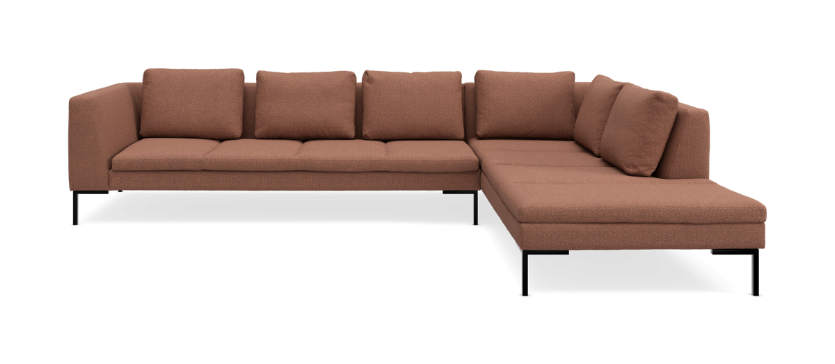 L‑formad modulsoffa i varm terrakottafärgat tyg med svarta metallben, frilagd i studiobild.