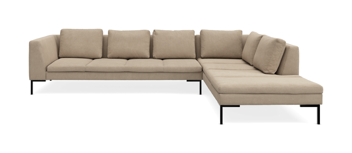 Beige L‑formad modulsoffa med schäslong åt höger och svarta metallben, frilagd mot vit bakgrund, frontvy.