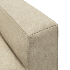 Närbild av beige soffa med tygklätt, rektangulärt armstöd och rena sömmar.