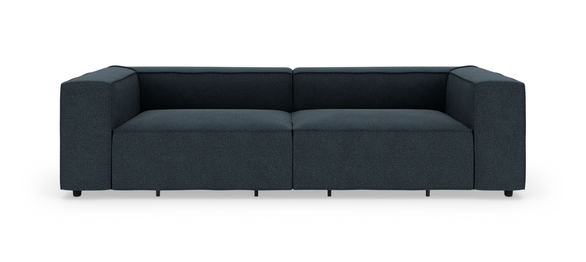 Mörkblå, låg modulsoffa i modern, boxig design frilagd mot vit bakgrund, sedd rakt framifrån.