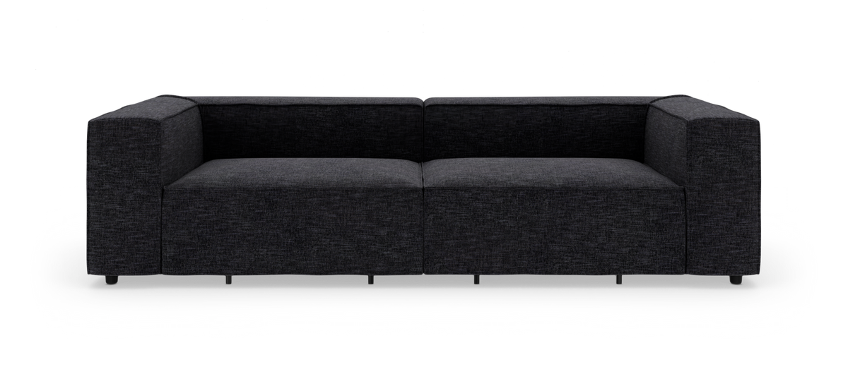 Mörkgrå modulsoffa med tjocka armstöd, fotograferad framifrån i studio på vit bakgrund.