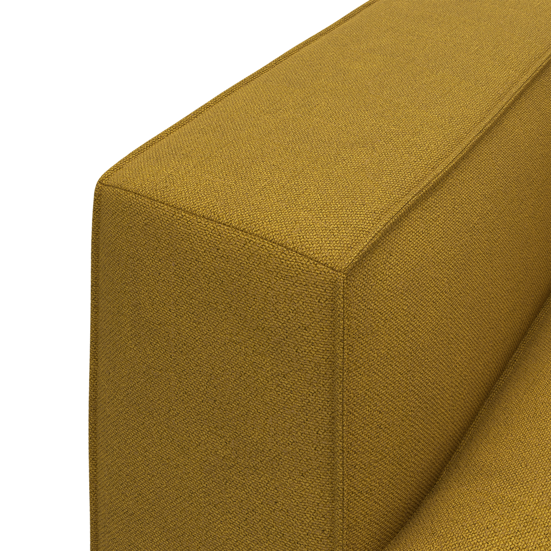 Detaljbild av en senapsgul soffa med grovvävd textil och skarpa sömmar.