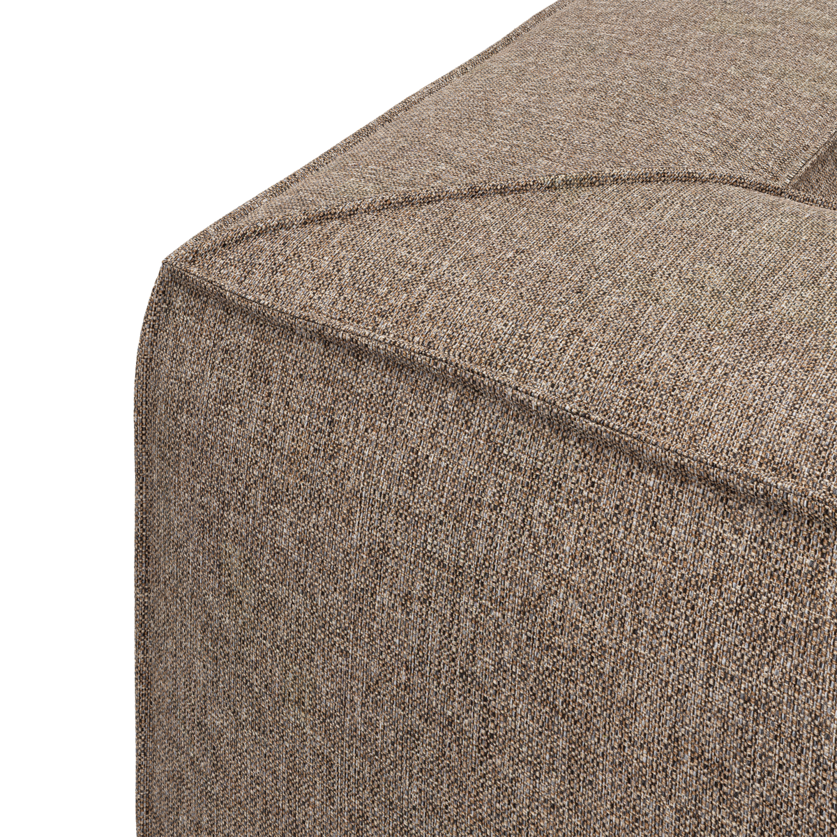 Närbild av hörnet på en beige, texturerad sittpuff/soffmodul med synliga sömmar och slät, vävd klädsel.