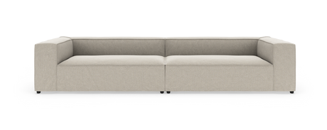 Beige, modern modulsoffa med låga ryggar och breda armstöd, sedd rakt framifrån.