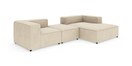 Beige modulsoffa i tyg – låg L‑formad hörnsoffa med bred chäslong, frilagd mot vit bakgrund.