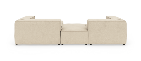 Beige modulsoffa sedd bakifrån med låg mittpall på vit studiobakgrund.
