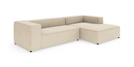 Beige L-formad modulsoffa med bred divan, låg rygg och blockarmstöd på vit bakgrund.