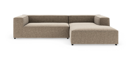 Modulsoffa i L-form med breda armstöd och chaise longue till höger i beige tyg, frilagd mot vit bakgrund.