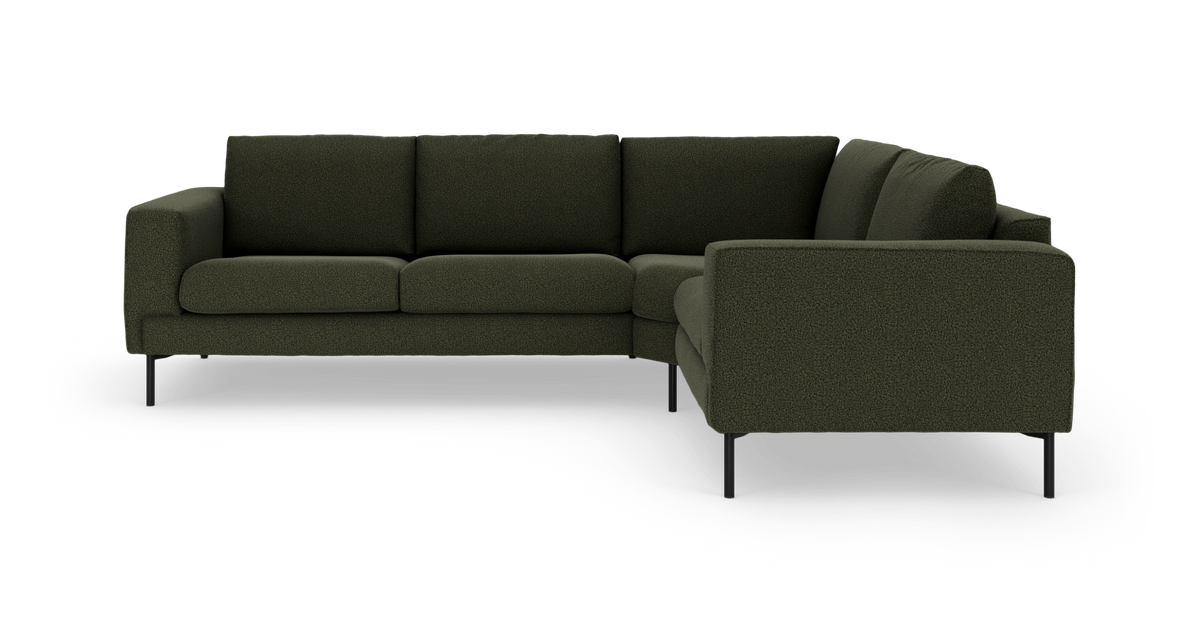 Mörkgrön L-formad modulsoffa i tyg med slanka svarta ben, modern design.