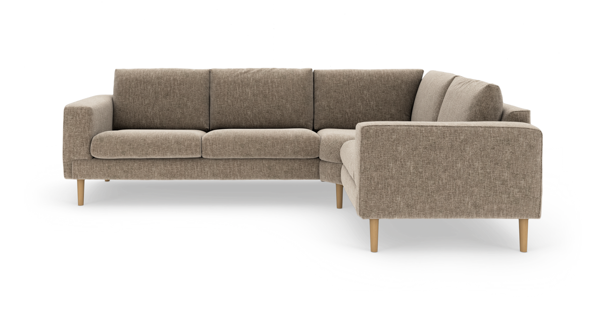 Beige L‑formad hörnsoffa i tyg med träsben, fyra sittplatser och högervänd divan.