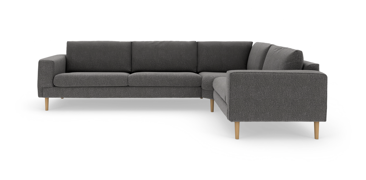 Mörkgrå L‑soffa i tyg med träben, modern minimalistisk design, produktbild mot vit bakgrund.