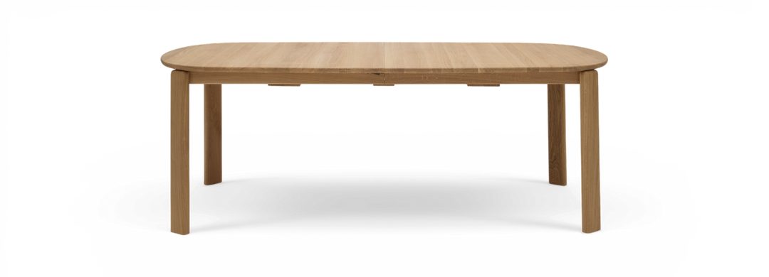 Rektangulärt matbord i ljus ek med mjukt rundade hörn och raka ben, frilagd produktbild.