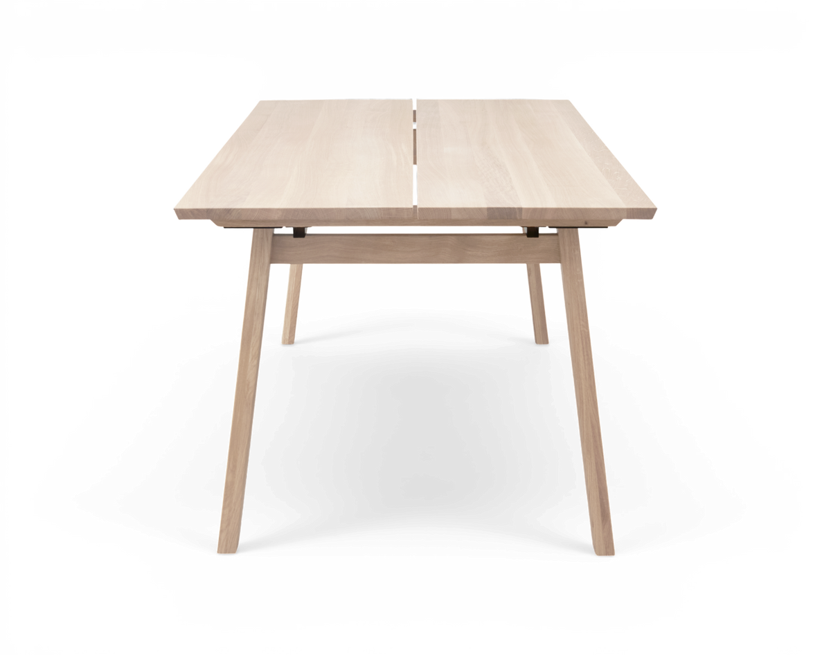 Ljus ekfärgat matbord i minimalistisk design, frilagt mot vit bakgrund.