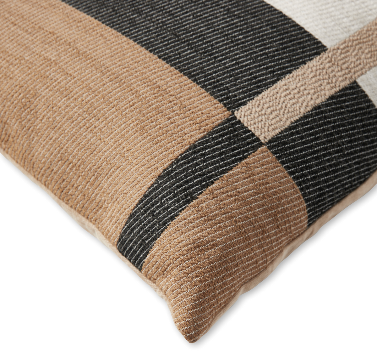 Närbild av kudde med geometriskt mönster i beige, svart och vitt.