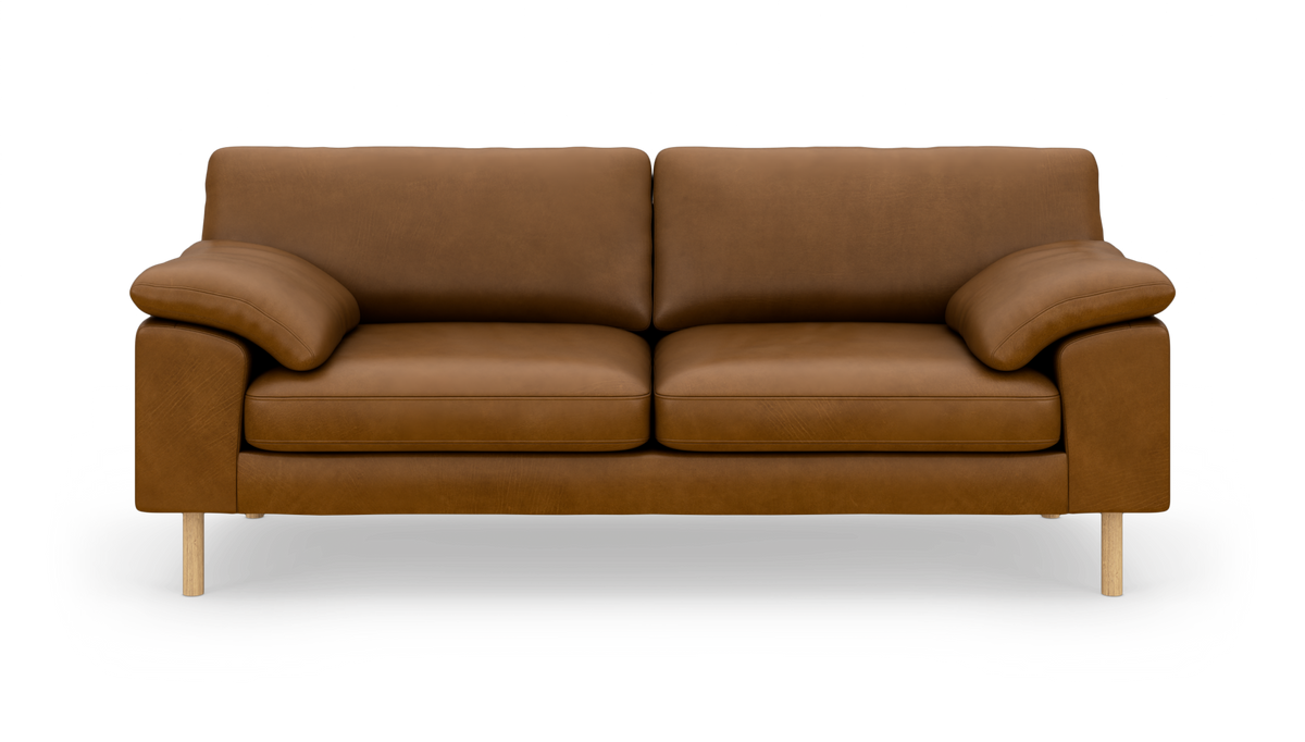 Brun lädersoffa med två sittdynor och träben, fotograferad rakt fram på vit bakgrund.