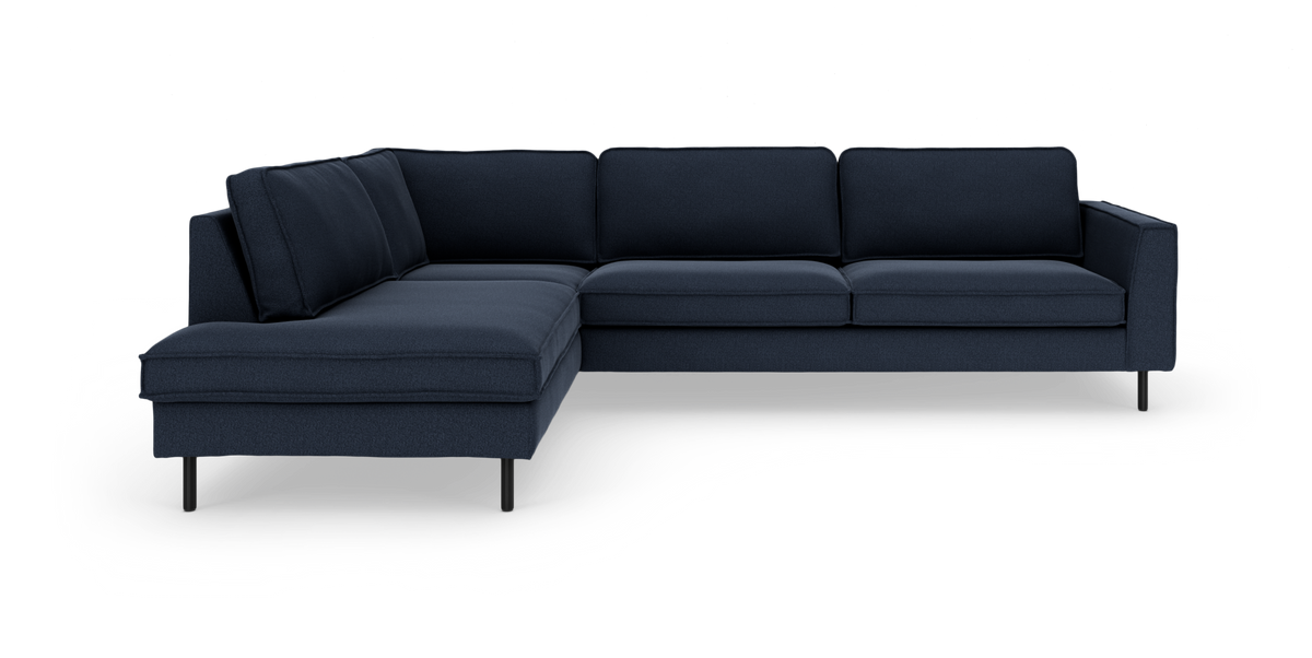 Mörkblå L‑soffa med vänster divan, slanka svarta ben och modern design på vit bakgrund.