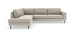L-formad modulsoffa med vänster schäslong i ljus beige tyg och smala svarta metallben, frilagd på vit bakgrund.