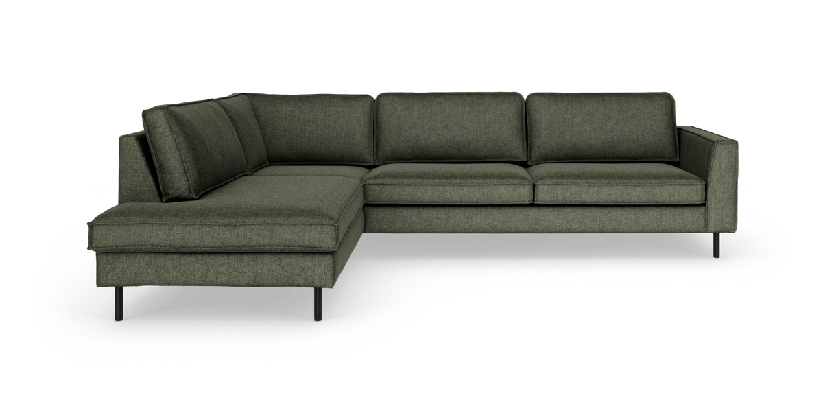 Grön L‑soffa med schäslong till vänster, modern design på smala svarta ben.