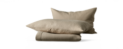 Beige quiltade kuddar med matchande vikt överkast.