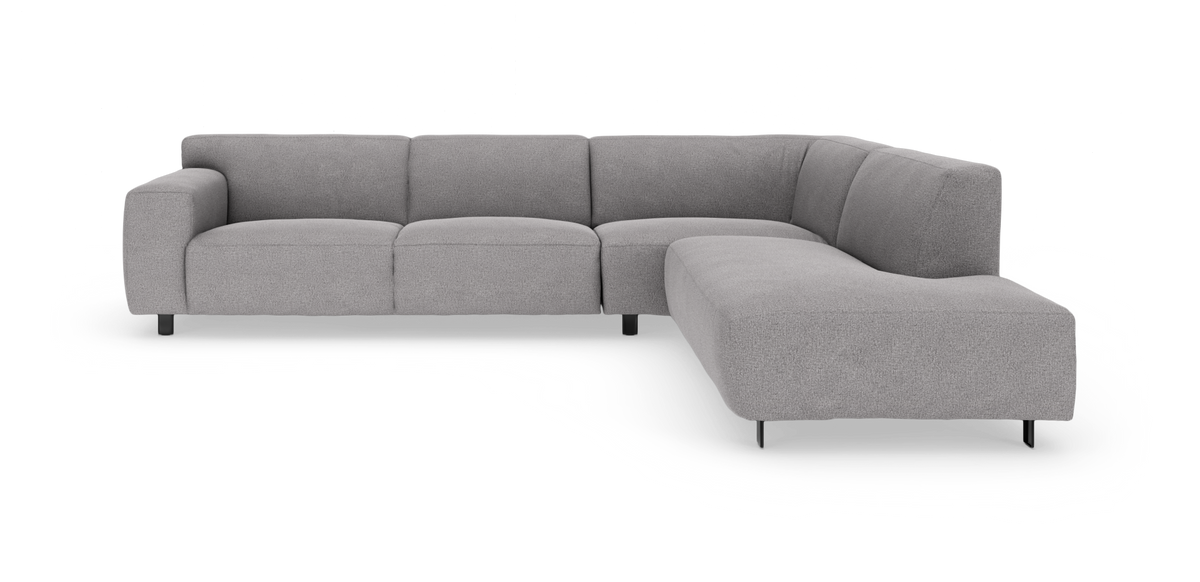 Hörnsoffa i L-form i ljusgrått tyg med rundade armstöd och smala svarta metallben, modern stil.