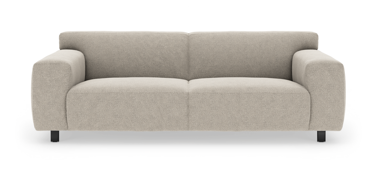 Beigefärgad modern 3‑sits soffa med rundade armstöd och svarta ben, frilagd mot vit bakgrund.