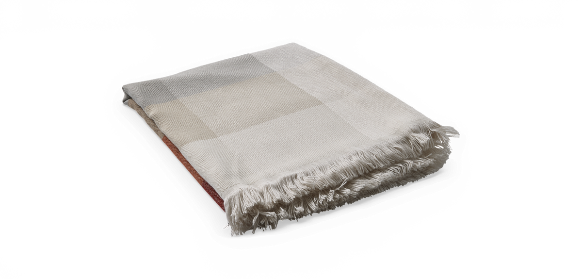 Vikt rutmönstrad pläd i beige och vitt med fransad kant, produktfoto mot svart bakgrund.